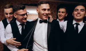 Uśmiechnięci panowie w garniturach, przygotowani na wieczór kawalerski.